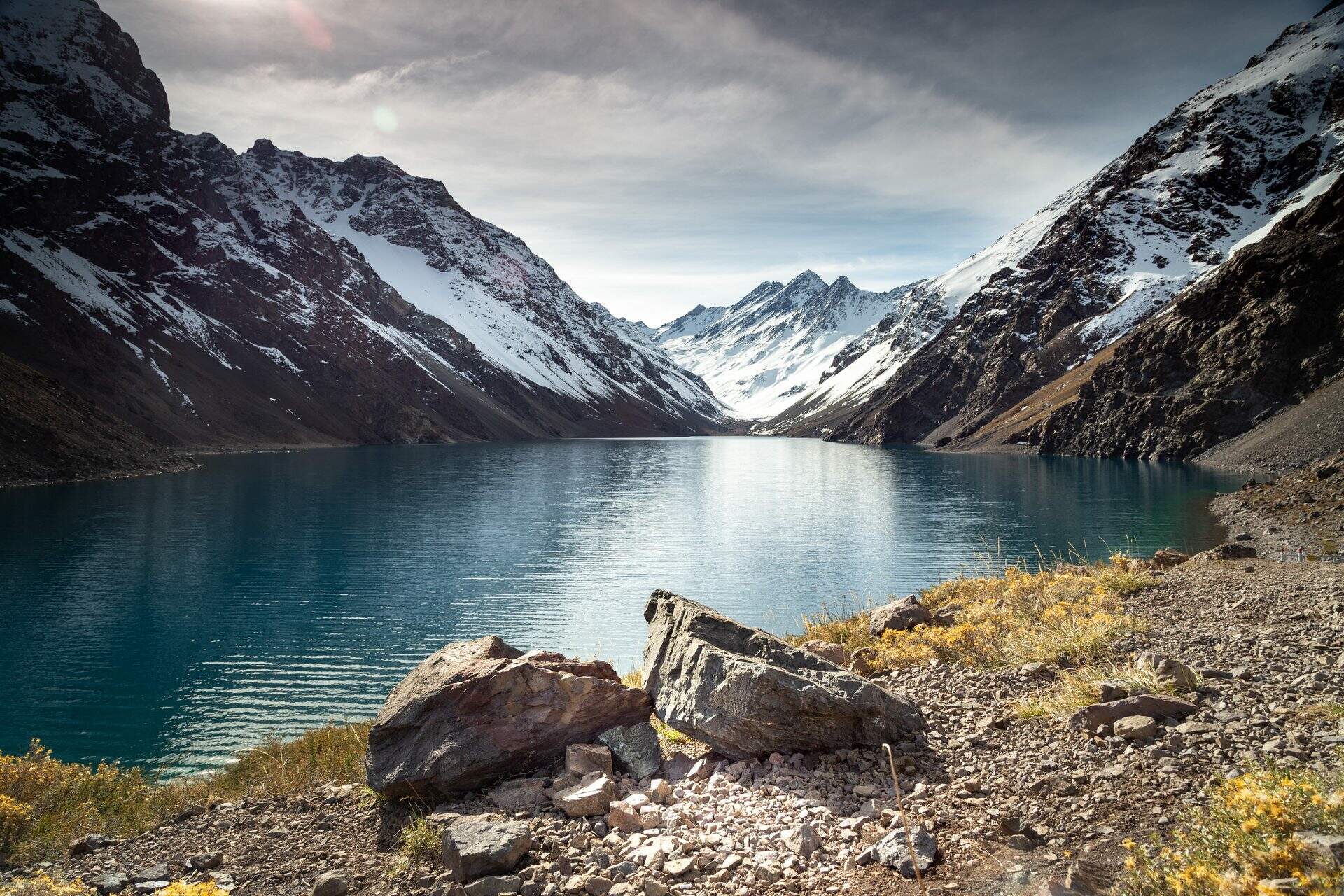 Laguna del Inca lake surrounded by high mountains covered in snow in Chile